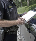 Policeman writing speeding ticket.